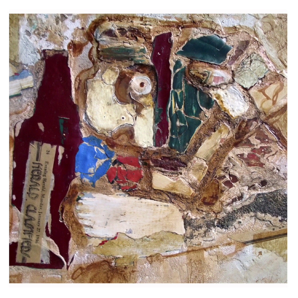 Fragments of old paint and plaster embedded in mortar, forming a textured mixed media surface.