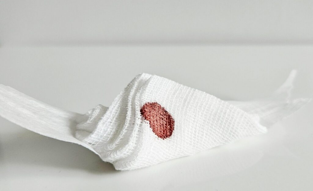 Cotton swab with a spot of blood on a white surface