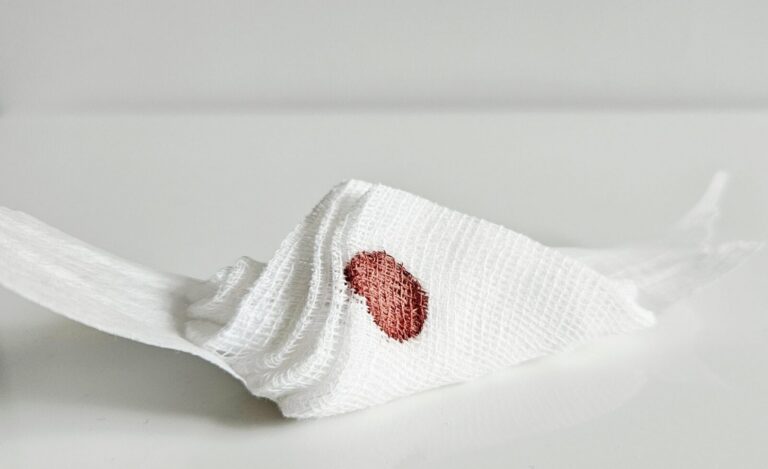 Cotton swab with a spot of blood on a white surface